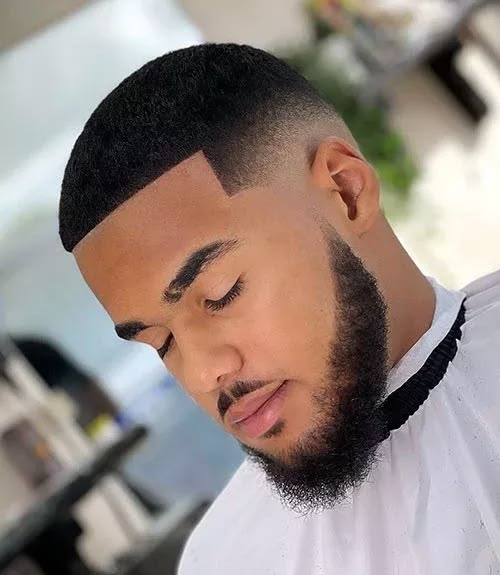 Coupe afro courte avec lineup géométrique et barbe connectée